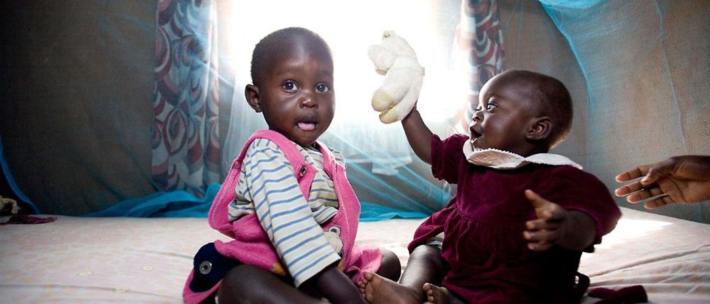 Tansania: Zwei Babys sitzen unter einem Moskitonetz © MHallahan/Sumitomo Chemical