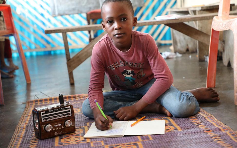 Corona in Kamerun: Ein Junge nimmt zuhause per Radio am Unterricht teil