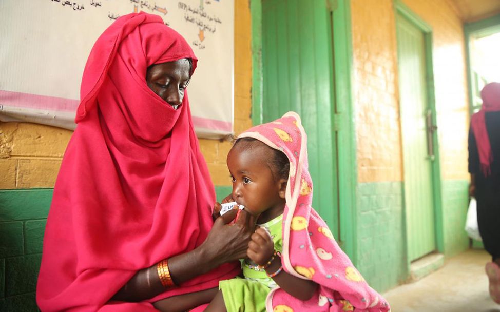 Mangelernährung im Sudan: Eine Mutter füttert ihrer Tochter Erdnusspaste