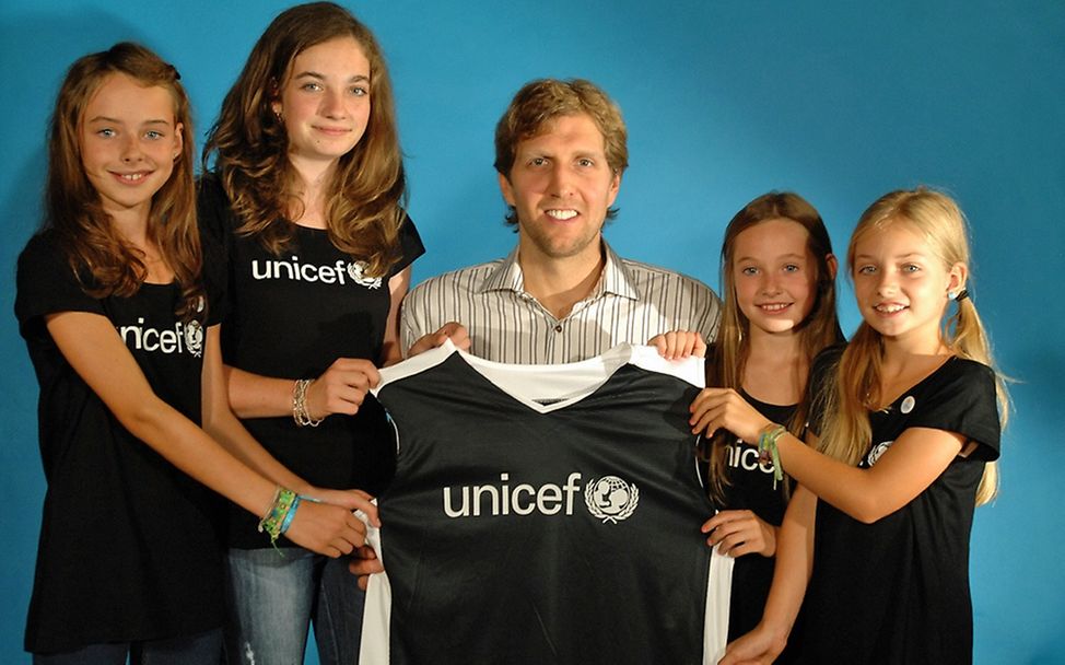 JuniorBotschafterinnen überreichen Dirk Nowitzki ein UNICEF-Trikot. 