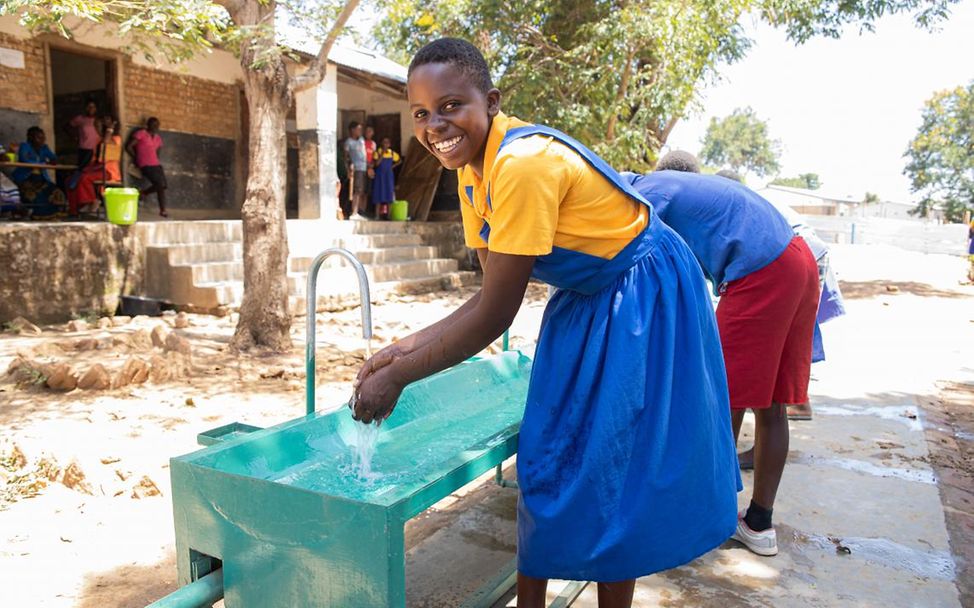 Schulen für Afrika Malawi: Schüler*innen waschen ihre Hände an einer Outdoor-Waschstation. 