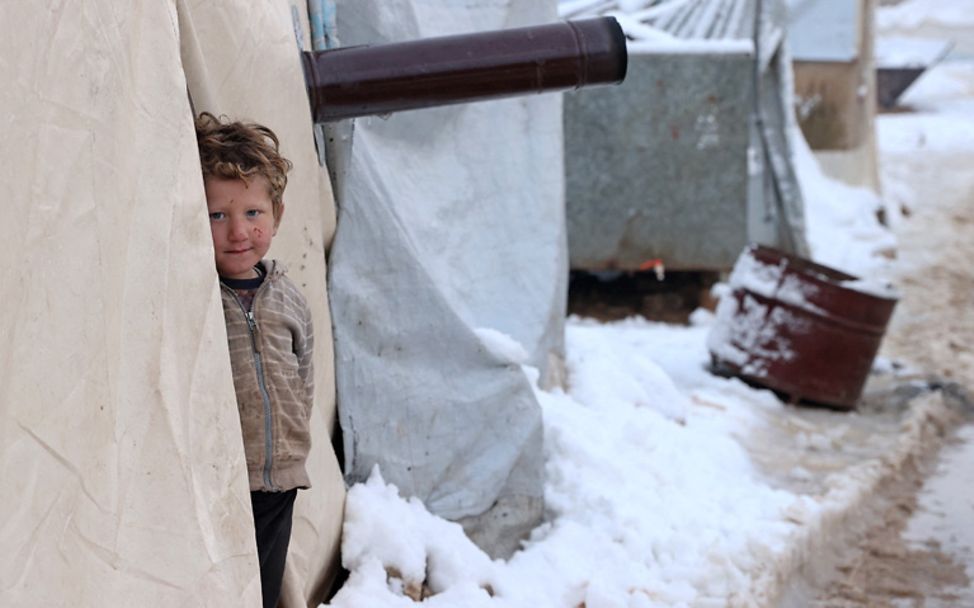 Syrien Krieg im Winter 2022: Ein Junge steht im Schnee am Eingang eines Zeltes