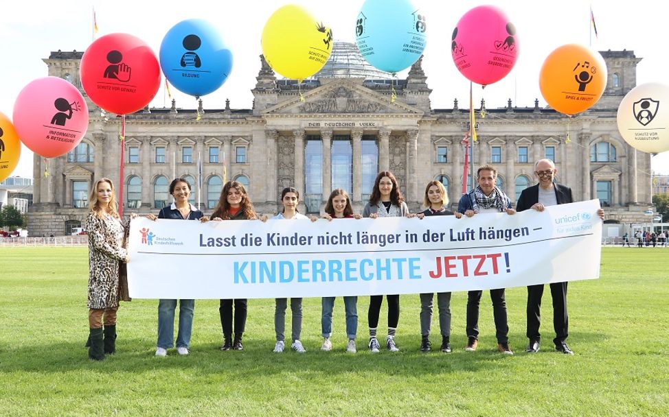 UNICEF und DKHW präsentieren ihre Forderungen zusammen mit Jugendlichen vor dem Reichstag.