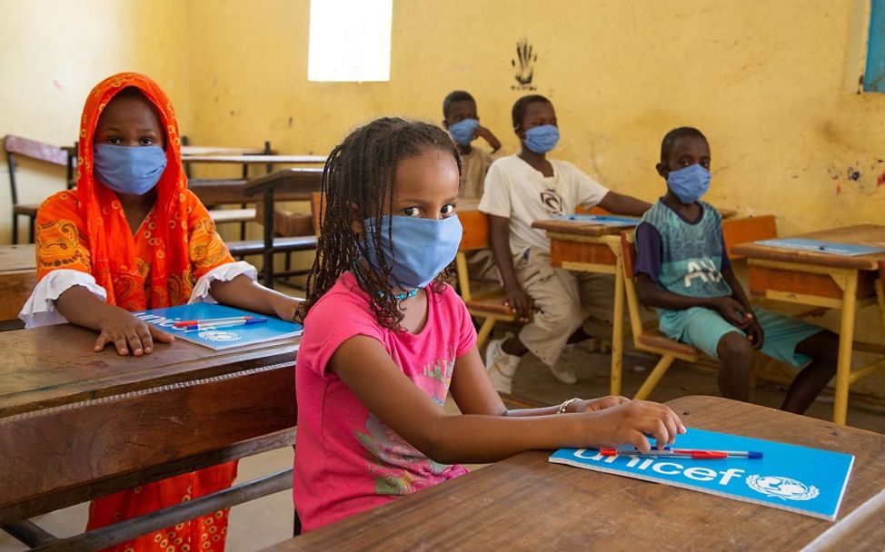 Schulkinder in Mauretanien sitzen mit Masken geschützt im Klassenzimmer.