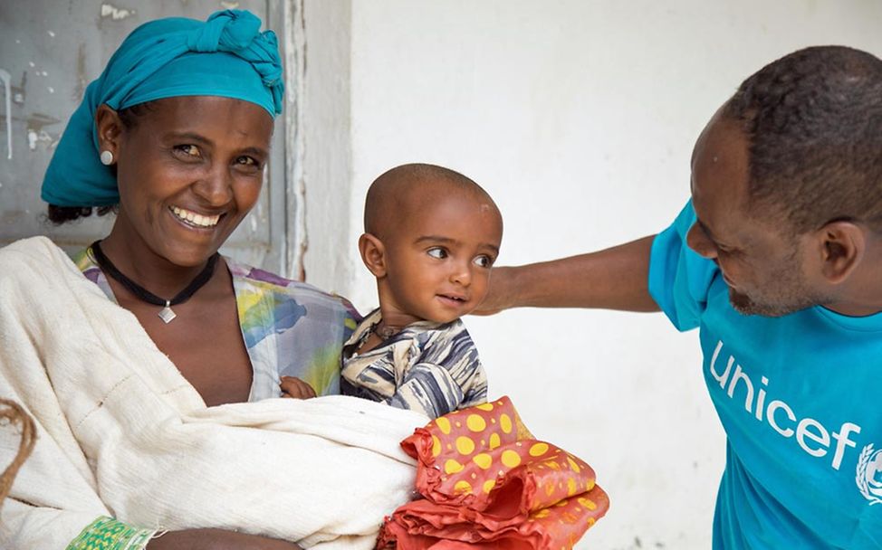 Hungerkrise Tigray: Eine Mutter und ihr Baby mit einem UNICEF-Mitarbeiter. 