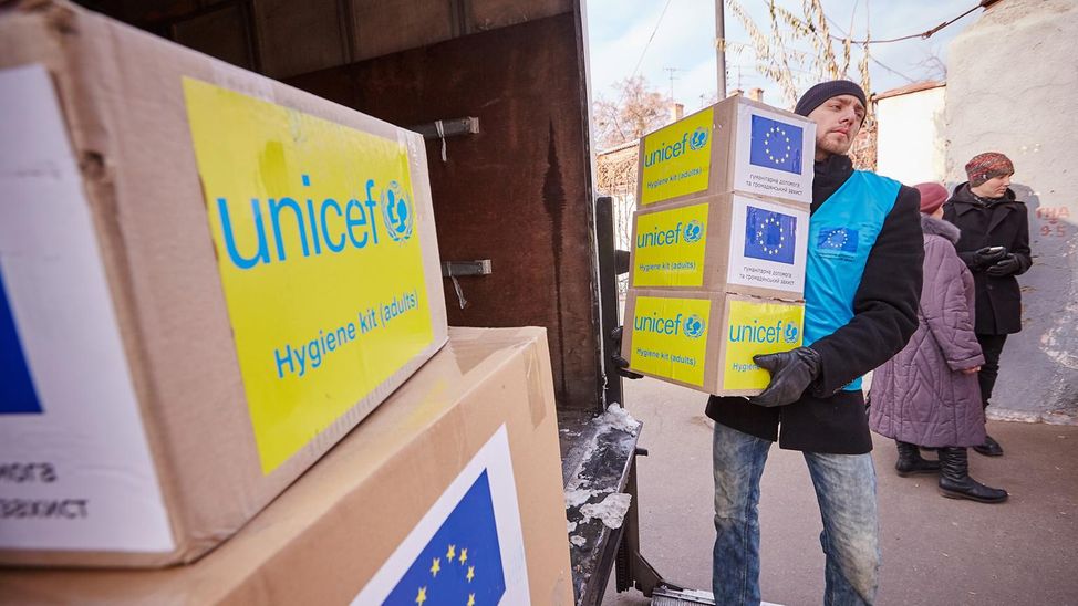 Hilfslieferungen erreichen den Osten der Ukraine. Ein Helfer lädt diese aus einem Auto aus.
