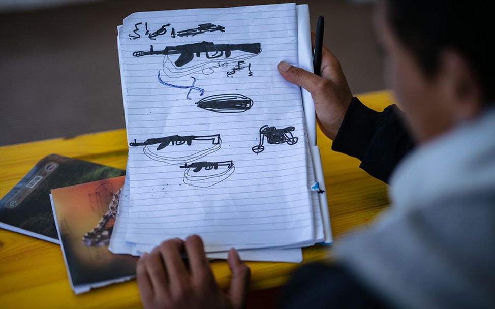 Kindersoldaten Jemen: Ein ehemaliger Kindersoldat malt Waffen in ein Heft