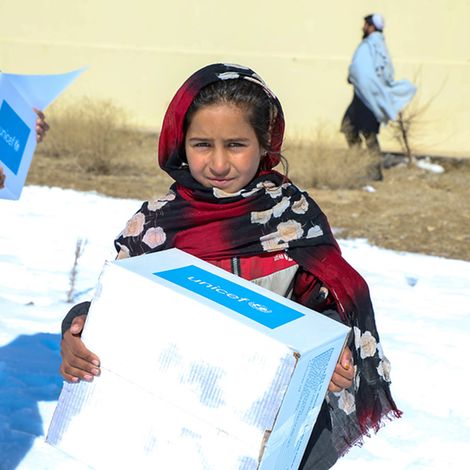 Afghanistan: Ein Mädchen trägt ein Paket mit Winterkleidung