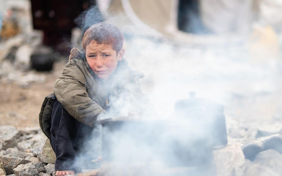 Afghanistan: Ein Junge wärmt sich an einem offenen Feuer