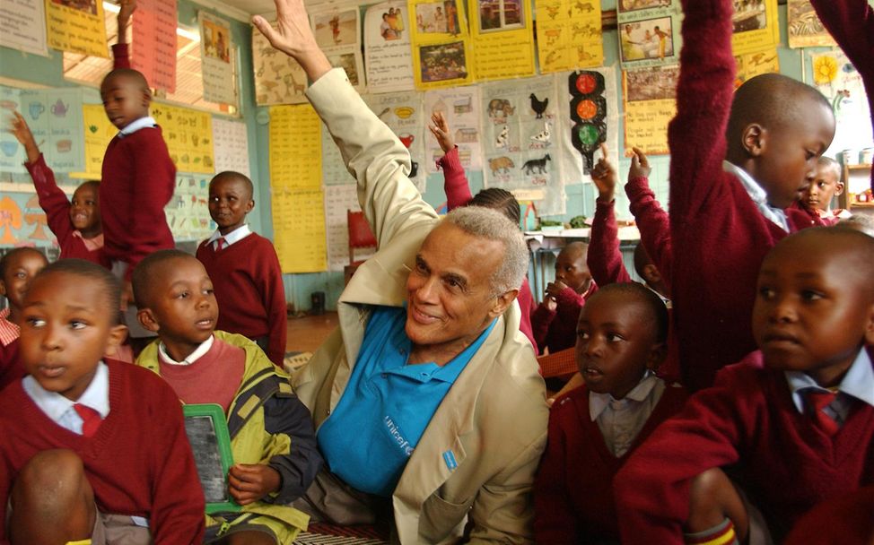 Harry Belafonte sitzt in einem Klassenzimmer in Nairobi