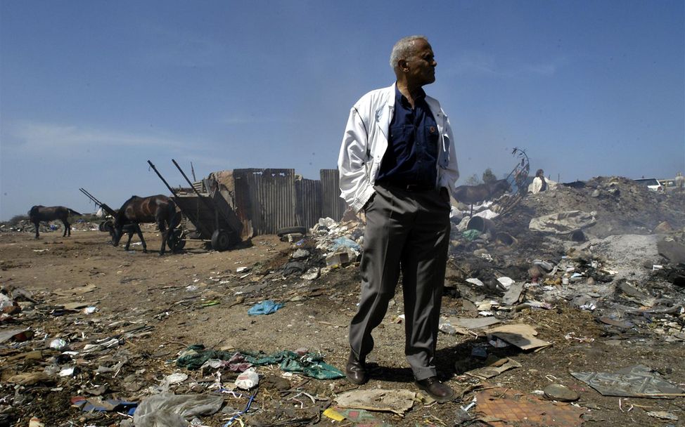 Belafonte steht inmitten von Müllbergen in einem Slum von Dhaka