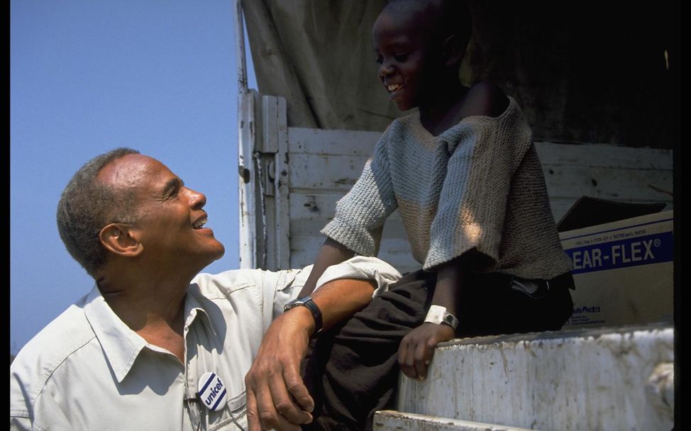 Ein ruandischesFlüchtlingsmädchen spricht mit Belafonte