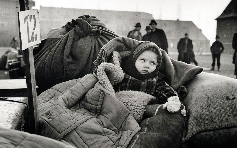 Ein kleines Mädchen mit Hilfsgütern im kriegszerstörten Deutschland der 1940er Jahre © UNICEF/UNRRA