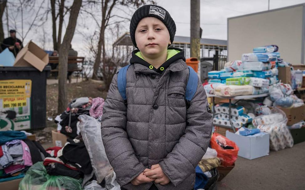 Ukraine Flüchtlinge Kinder: Hinter dem Grenzübergang nach Rumänien stapeln sich Hilfsgüter und Gepäckstücke.