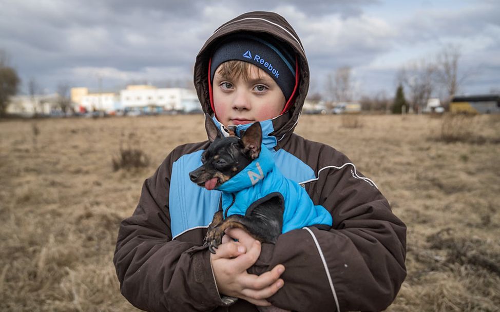 Ukraine Flüchtlinge Kinder: Alexander hält seinen kleinen Hund schützend im Arm. 