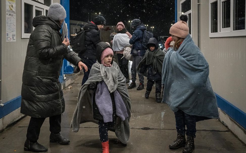 Ukraine-Konflikt: geflüchtete Kinder mit ihren Eltern kommen bei Schnee in Rumänien an.