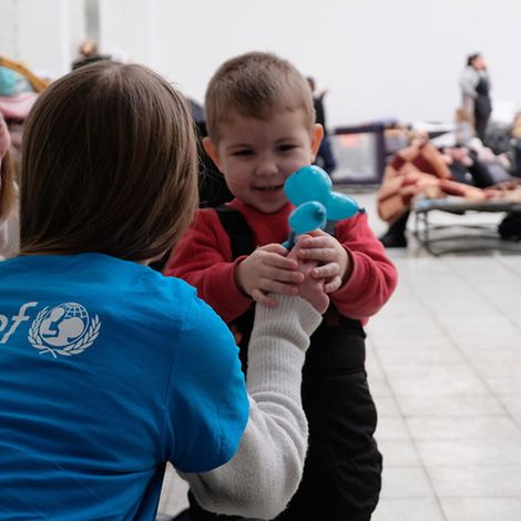 Ukraine Krieg: Eine UNICEF-Mitarbeiterin spielt mit einem Kind in einer Anlaufstelle für Flüchtlinge in Polen
