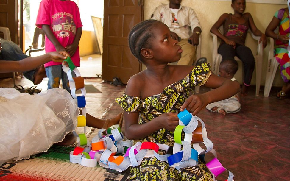 Ein Mädchen mit einer gebastelten Girlande. © UNICEF Sierra Leone/Angela Griep