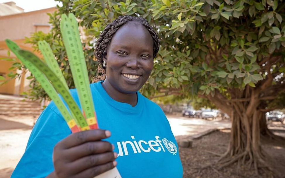 Hunger in der Welt: Eine UNICEF-Helferin in einem Entwicklungsland hält Maßbänder für Oberarmmessungen bereit. 