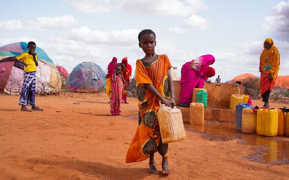 Somalia: Mädchen trägt einen Kanister mit Wasser in einem Flüchtlingslager