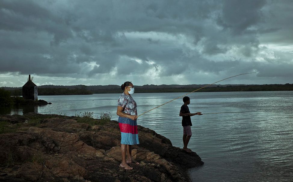 Brasilien: Caio steht mit seiner Großmutter am Fluss und angelt.