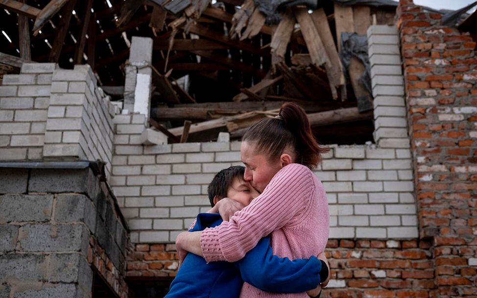 Ukraine-Krieg 100 Tage: Eine Mutter hält ihren Sohn fest im Arm und küsst ihn auf die Stirn. 