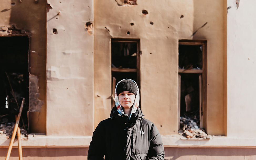 Ukraine-Krieg 100 Tage: Yaroslav steht vor seiner im Krieg angeschossenen Schule. 