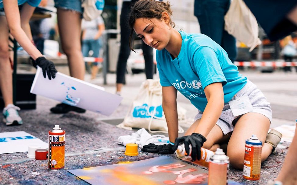 UNICEF YouthFestival: Eine Engagierte gestaltet ein Bild mit Spraydosen