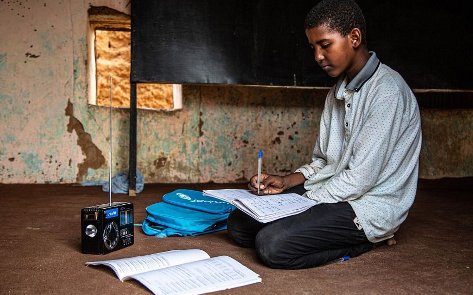 Mauretanien: Junge hört dem Unterricht über das Radio zu.
