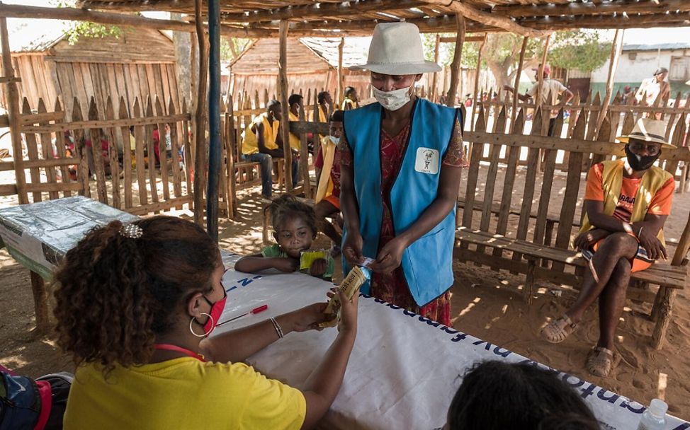 Eine Mutter aus Madagaskar erhält eine Auszahlung im Rahmen eines Cash-Programms von UNICEF.