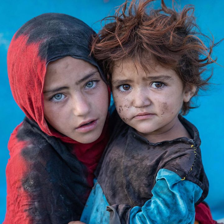 Afghanistan Kinder: Ein Mädchen trägt sein Geschwisterkind