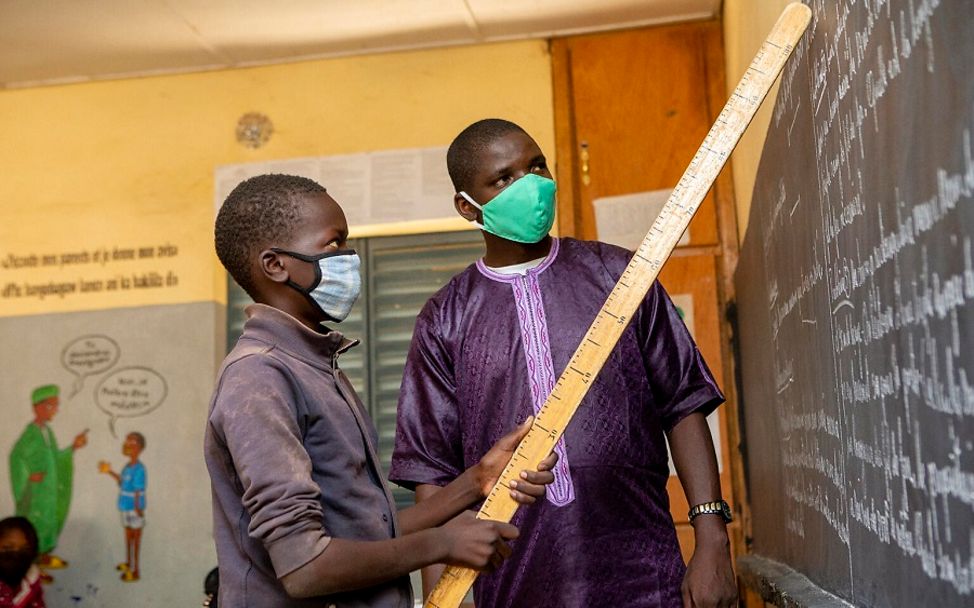 Mali: Makono steht mit seinem Lehrer an der Tafel.