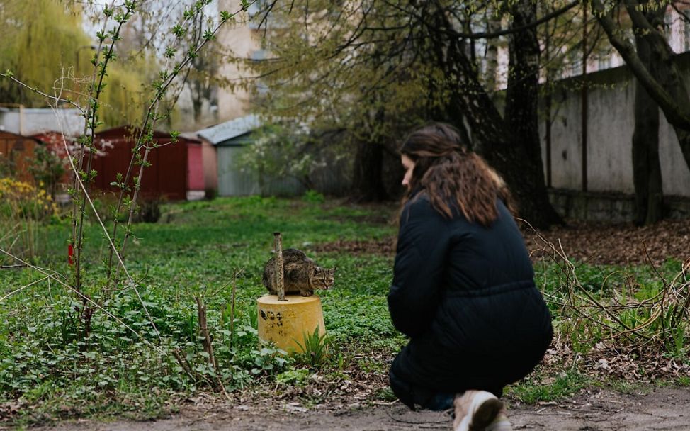 Ukraine: Viktoria spielt mit einer Katze im Garten.