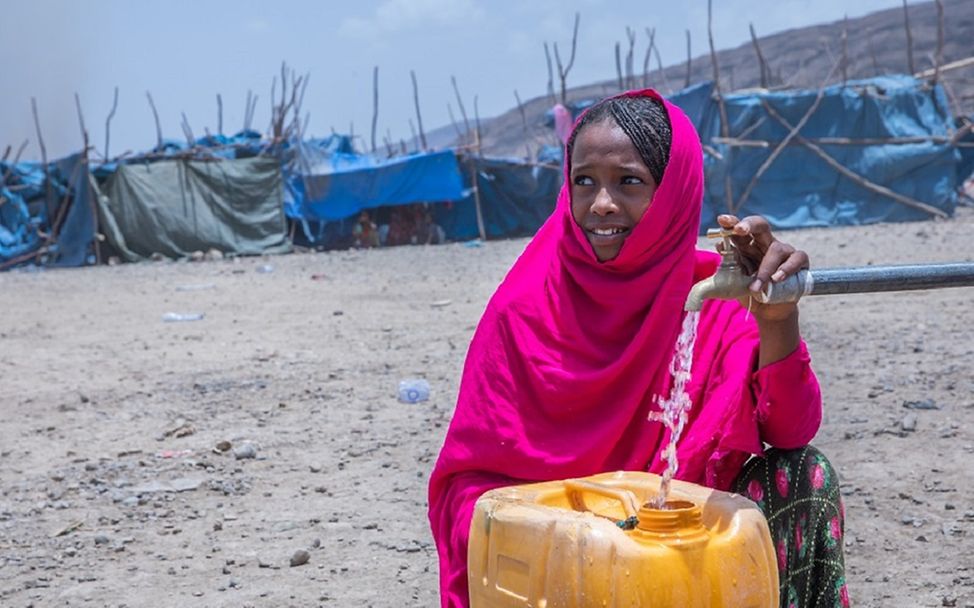 Äthiopien: Ein Mädchen füllt einen Eimer an einem Wassertank auf.