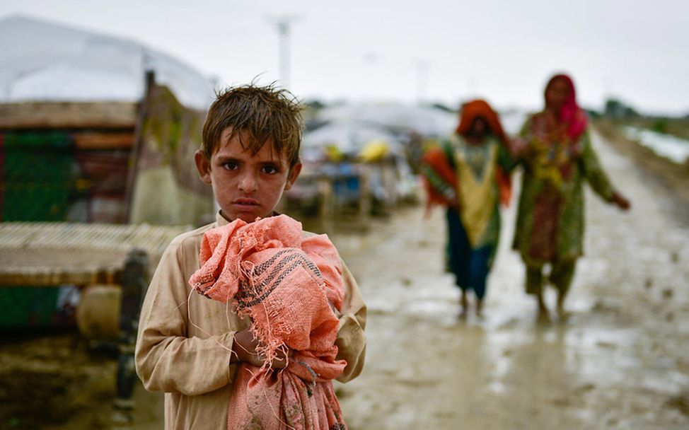 Monsun in Asien: Ein Junge steht im Schlamm nach Überschwemmungen in Pakistan