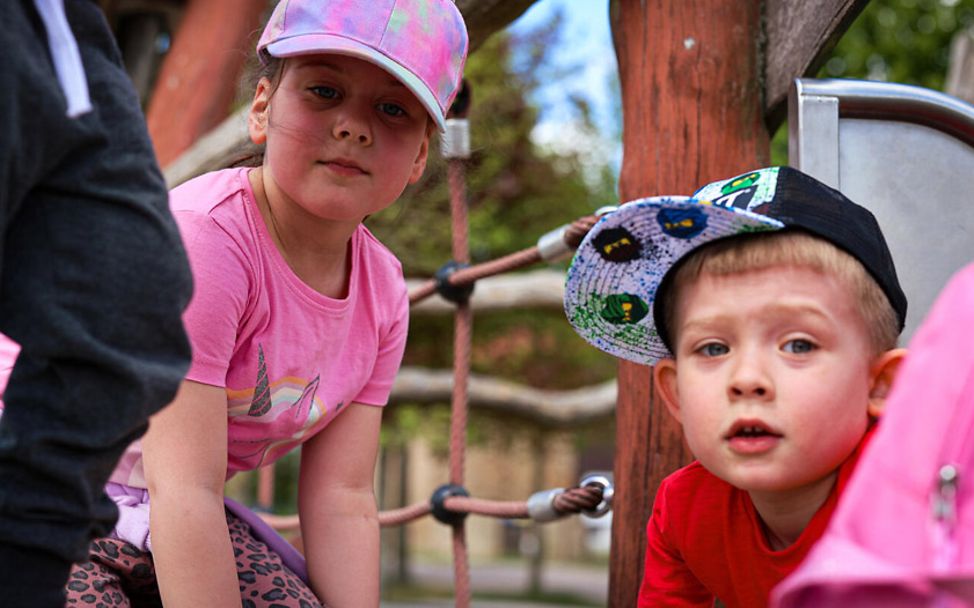 Ukraine Krieg: Geflüchtete Kinder spielen im Außenbereich eines Kindergartens in Deutschland