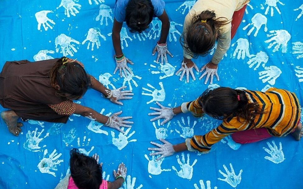 Madhya Pradesh: Kinder färben ein blaues Tuch mit ihren Handabdrücken.