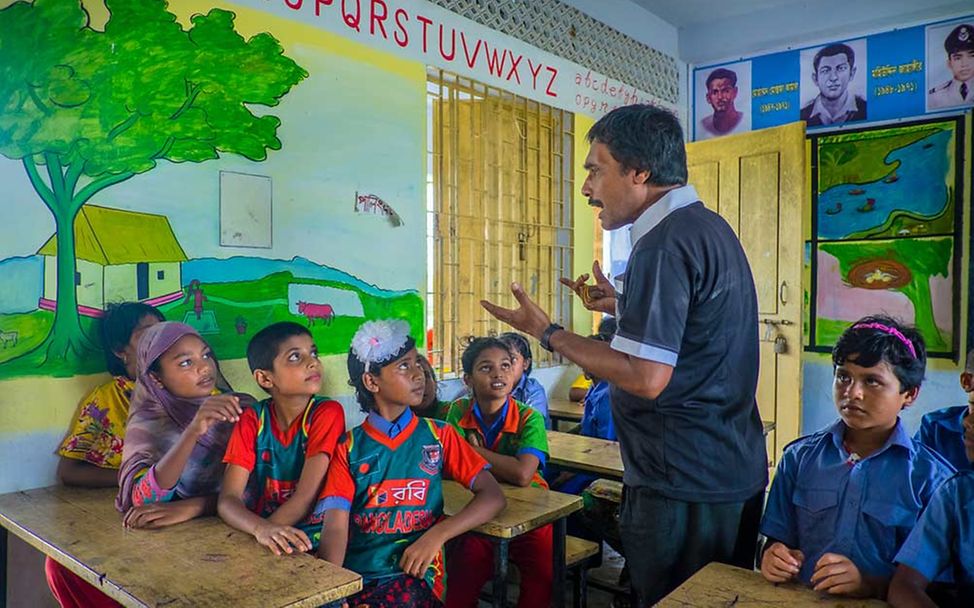 Spenden Bangladesch: Ein Lehrer unterrichtet eine Schulklasse in Bangladesch. 