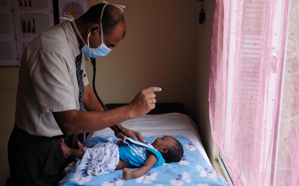 Ein Arzt untersucht ein Kleinkind auf einer Gesundheitsstation.