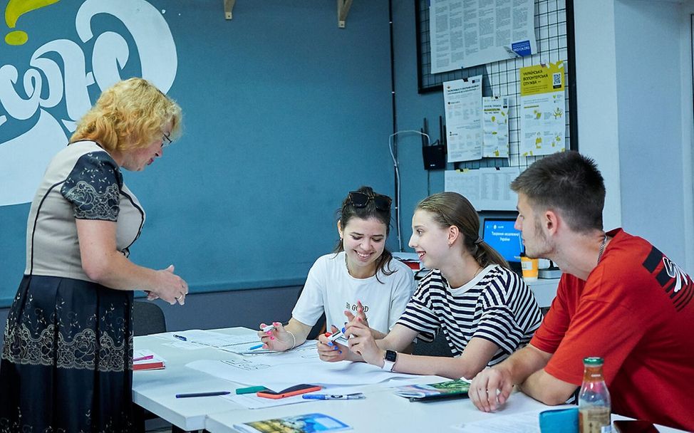 UNICEF | Hilfe für Kinder in der Ukraine: Eine Lehrerin spricht mit drei Schülerinnen.