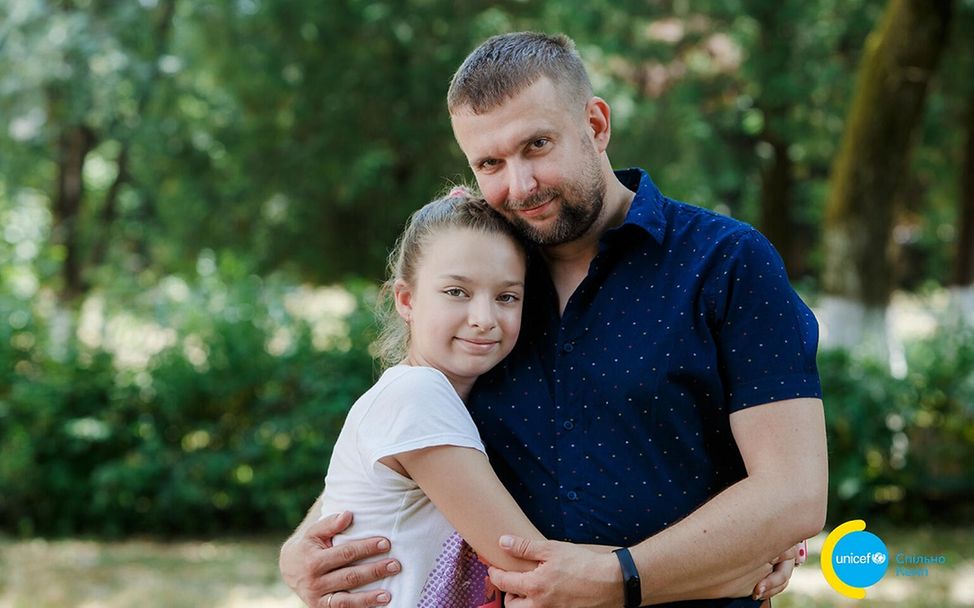 UNICEF | Hilfe für Kinder in der Ukraine: Dasha kuschelt sich an ihren Vater Oleksander.