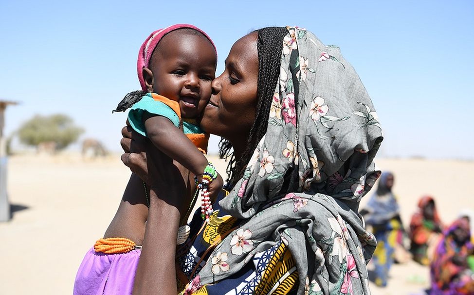 Tschad: Eine Mutter küsst ihr Kind auf die Wange, das sie in den Armen hält.