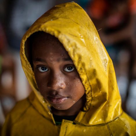 Kind aus Nicaragua in einer gelben Regenjacke.
