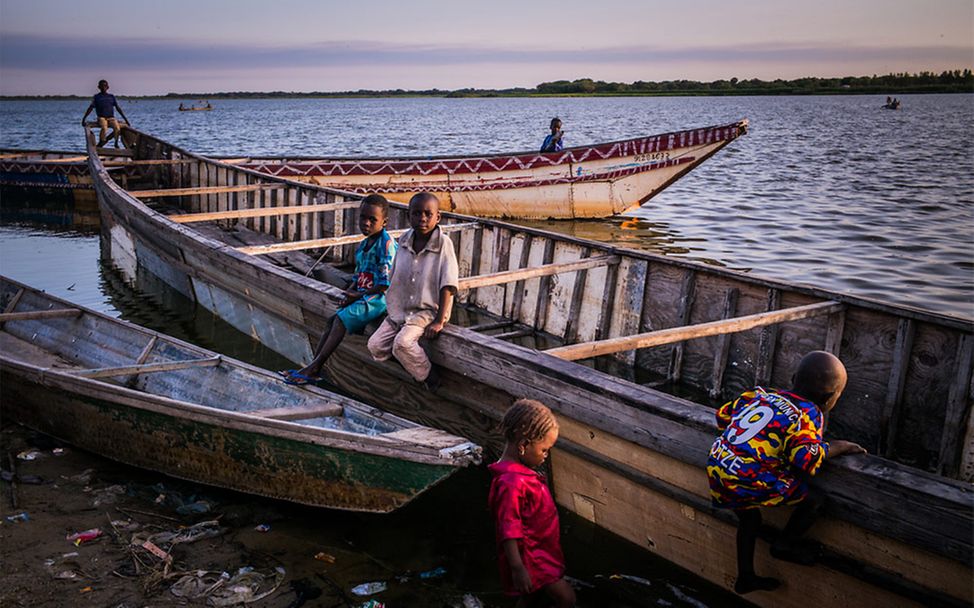 klimawandel folgen kinder: Kinder aus Tschad sitzen auf einem Boot.
