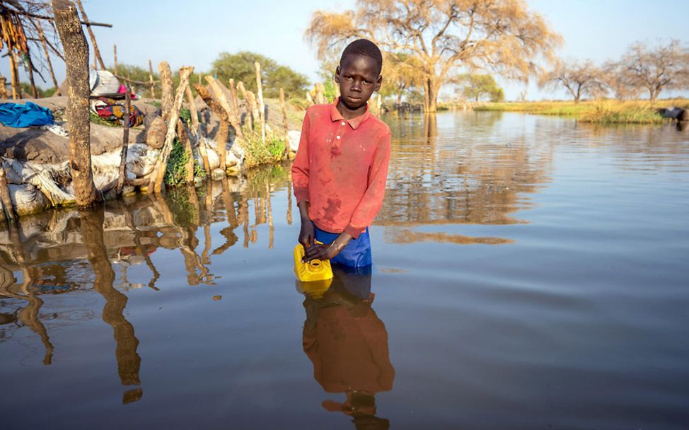 Südsudan: Der 13-jährige Mathiei Makuol sammelt schmutziges Flutwasser.