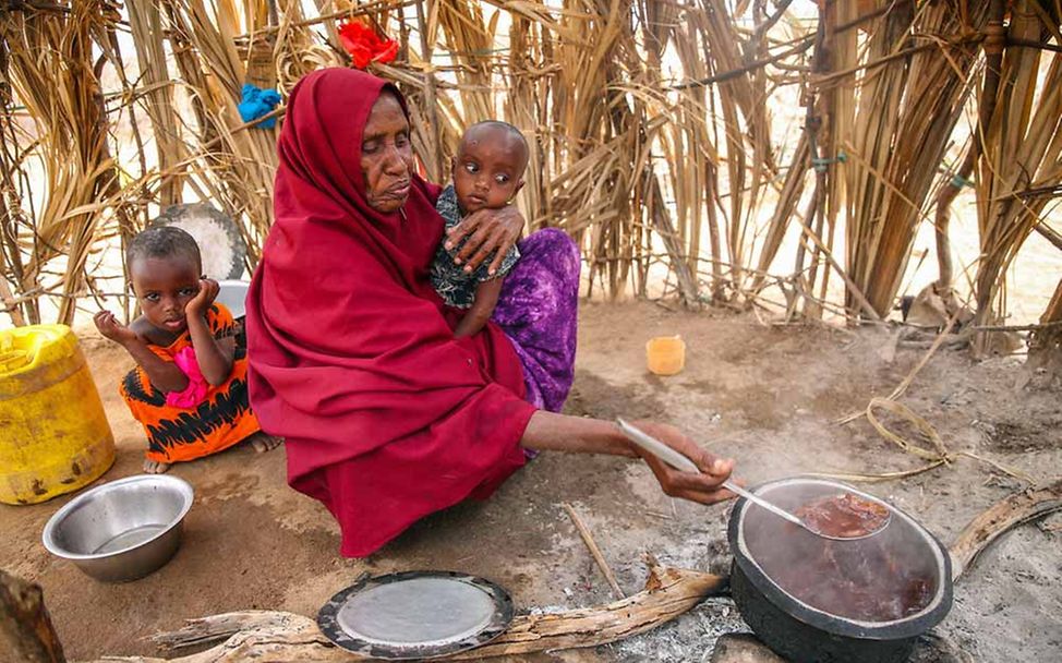 Kenia Hungerkrise: Eine kenianische Frau kocht das Essen für ihre Enkelkinder. 