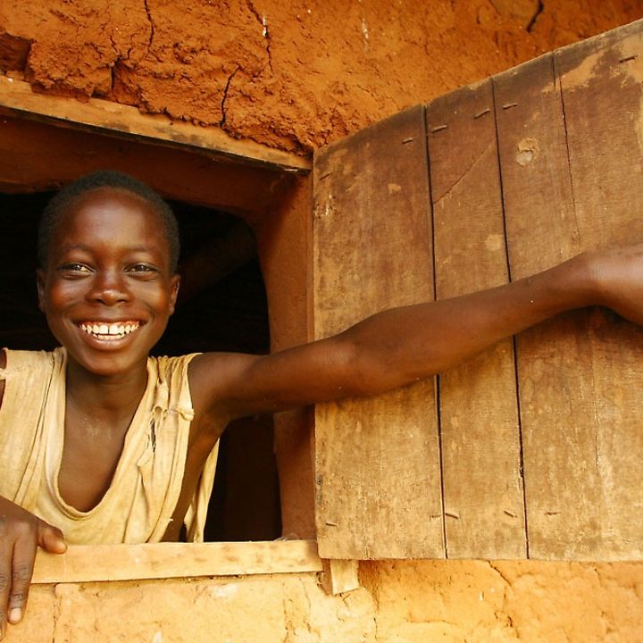Ein Junge schaut lächelnd aus einem Fenster, © UNICEF/BENA2004-00270/Pirozzi