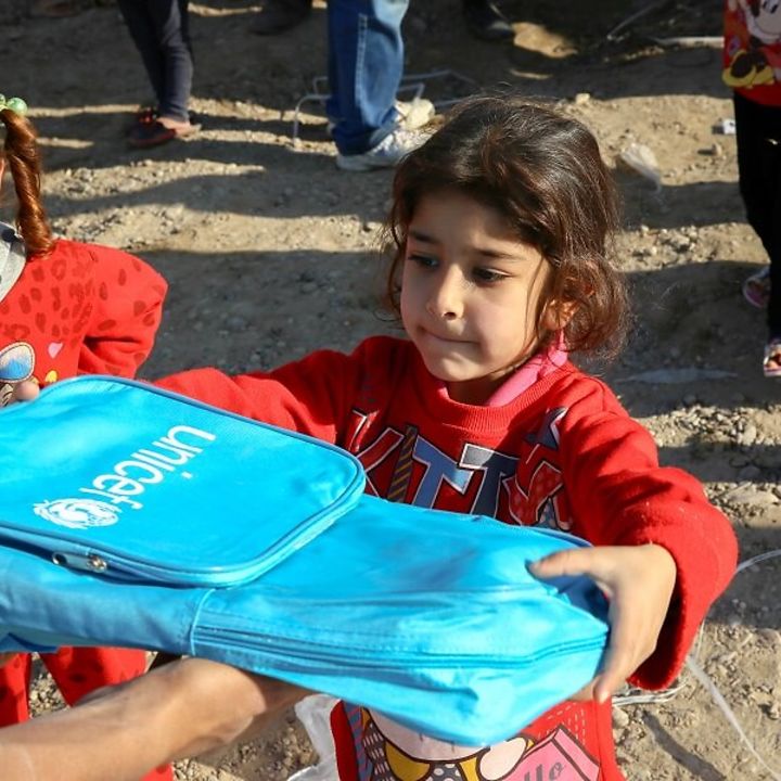 Ein Mädchen erhält den UNICEF Schulrucksack