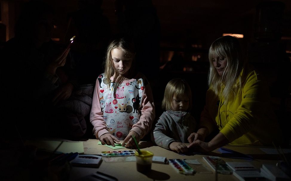 Ukraine: Zwei Kinder stehen an einem Tisch und malen.