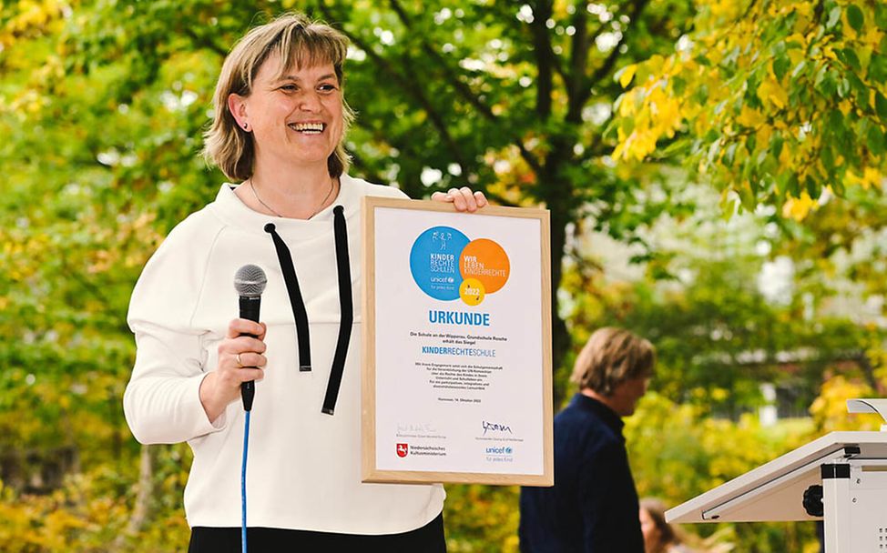 UNICEF-Kinderrechteschule: Schuldirektorin Susanne Prehm zeigt stolz die Urkunde 